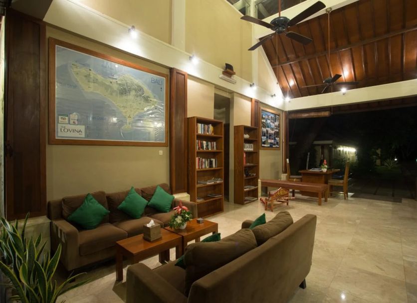 Bali Lovina Beach Cottages lobby with seating, bookshelves and open-air view in Buleleng