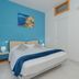 Tra i Monti in Tramonti: bright guest room with double bed, blue accent wall, and sea-themed artwork