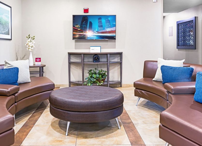 Candlewood Suites Killeen - Fort Hood Area lobby seating area with leather chairs and wall-mounted TV
