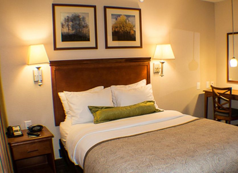 Candlewood Suites Jacksonville By IHG guest room with queen bed, bedside lamps, and small desk