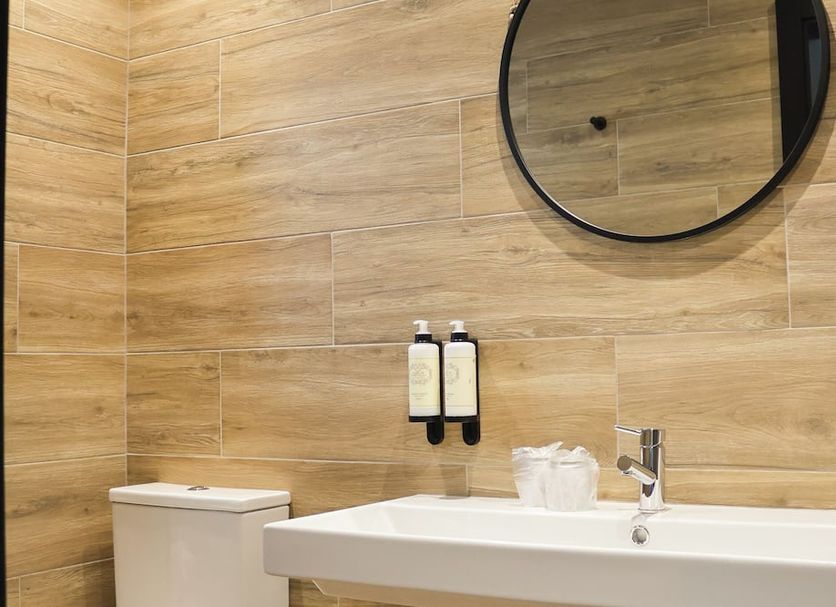 Quinta da Seixeda bathroom in Alijo with wood-look tile walls, round mirror and sink
