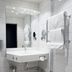 Vann Spa Hotell & Konferens in Brastad bathroom with wall-mounted sink, mirror, towel rack, and tiled shower area