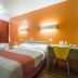 Motel 6 Lakewood, Co - Denver room with bed, desk, and orange accent wall