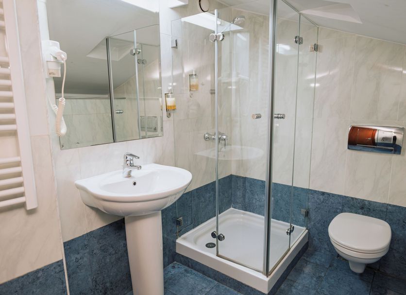 Hotel Duke Romana Bucharest bathroom with glass shower, pedestal sink and wall-mounted toilet
