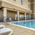 MainStay Suites Midland outdoor pool with lounge chairs beside the hotel building