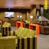 HG Alto Aragón in Formigal lounge with green and brown armchairs, orange tables, and a fireplace