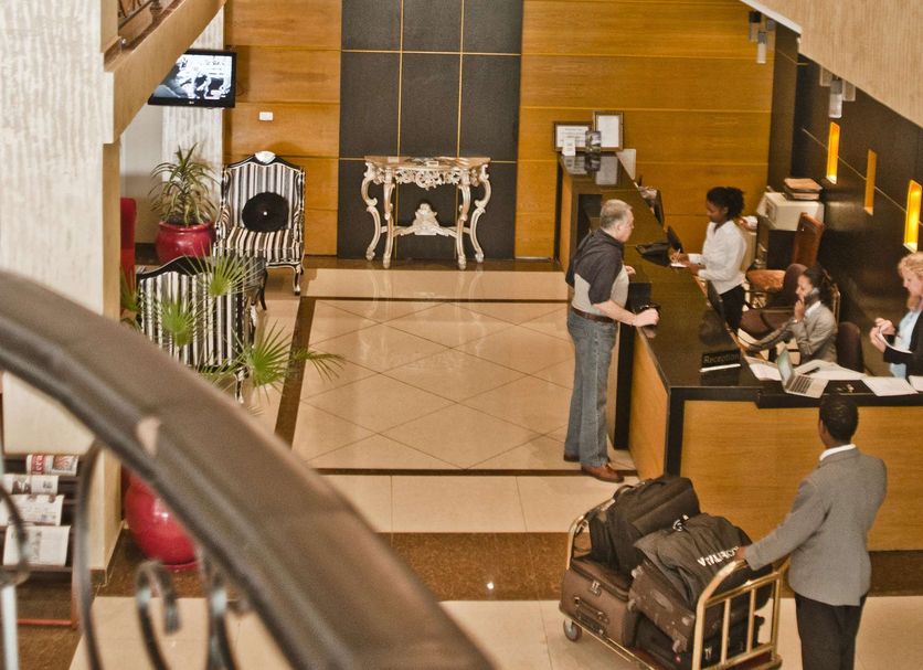 Ambassador Hotel Addis Ababa lobby with chandeliers, mezzanine railing, and a reception desk below