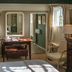 The Royal Oak, Chichester: elegant guest room with desk, armchair, dresser and window light.