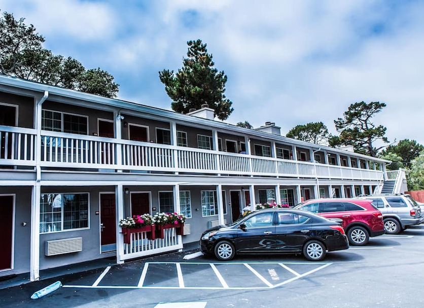 Pelican Inn Monterey exterior with two-story motel rooms and parked cars