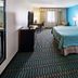 Wingate By Wyndham Lubbock Tx South guest room with king bed, TV, desk and blue accent wall