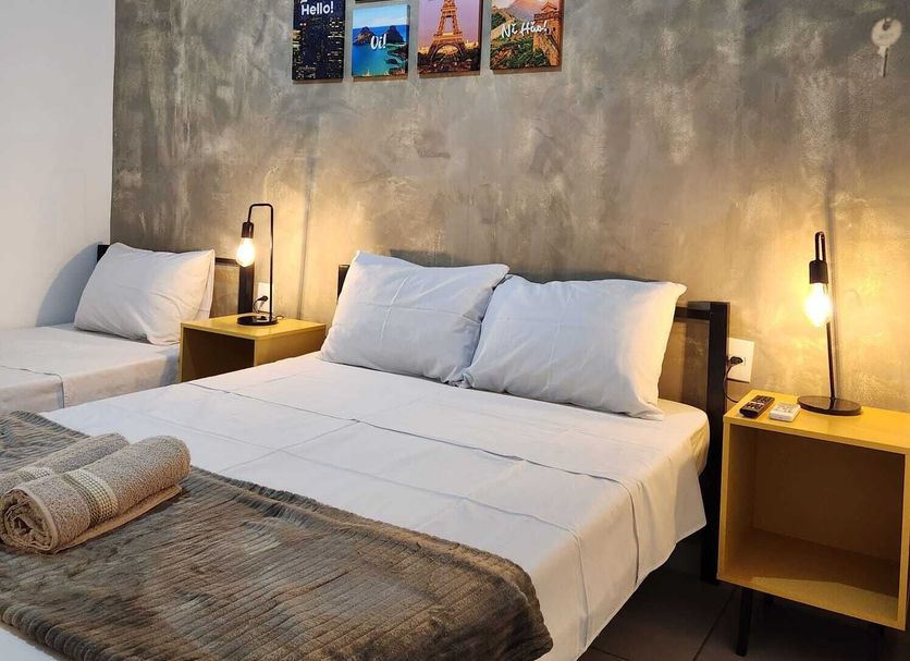 Bonito HI Hostel e Pousada room with two beds, bedside lamps and wall photo art in Bonito