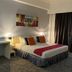 Hotel Seri Malaysia Genting Highlands guest room with a double bed, desk, wall art and dark curtains