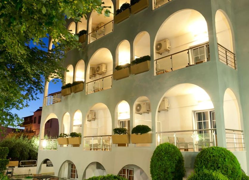Kronos Hotel in Platamon with illuminated arched balconies and landscaped exterior at night