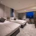 Hotel Jal City Nagasaki guest room with two beds, desk, and city view in Nagasaki