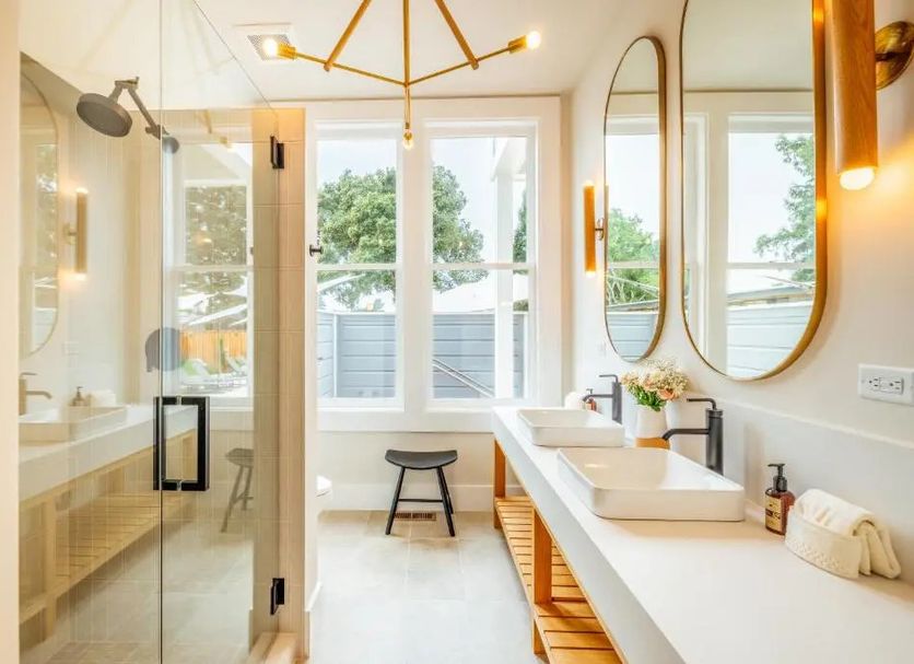 The Ruse in Healdsburg bathroom with double vanity, glass shower, and large windows with tree views