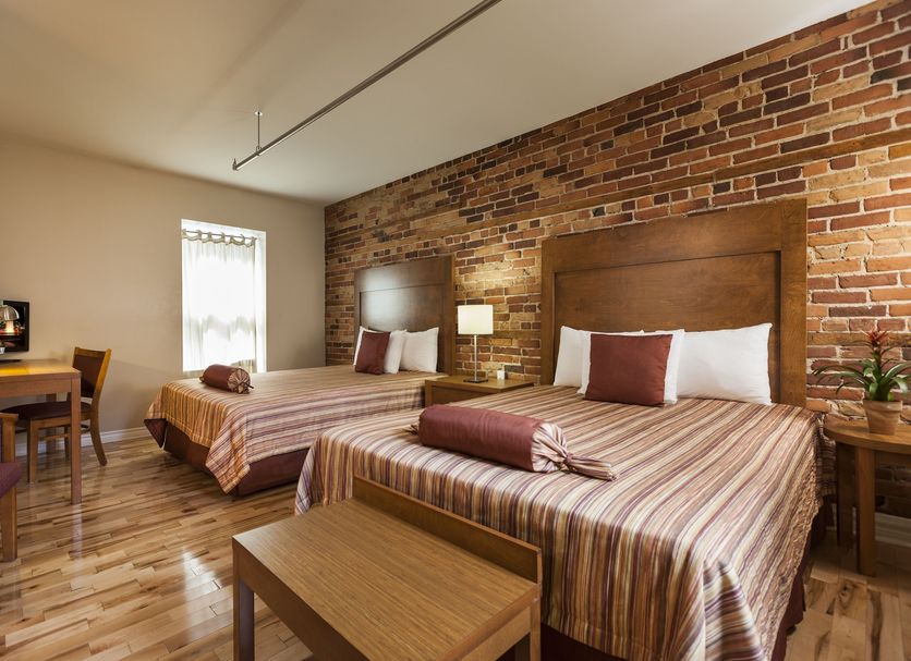 Hotel Quartier des Spectacles, Montreal: guest room with two beds, brick accent wall and wood floors