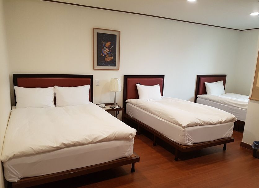 Youngbin Hotel Seoul room with three single beds and wood flooring