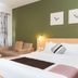 Hotel Tibera Taman Cibeunying Bandung room with bed, sofa, and green accent wall