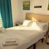 Hotel Mediterráneo by Croma in Estepona room with bed, balcony sea view, and teal curtains
