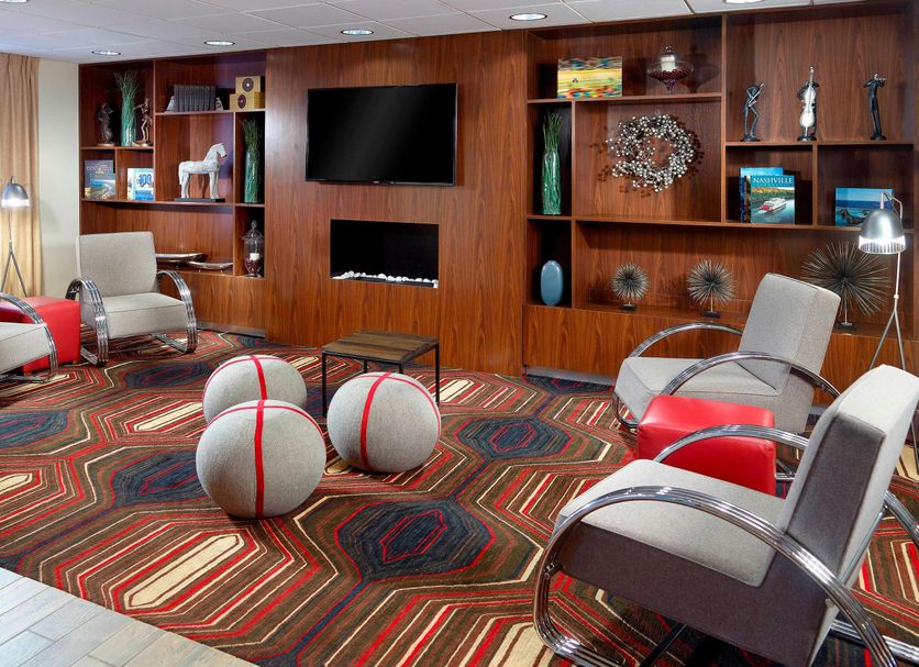 Four Points by Sheraton Nashville Airport lounge with seating, TV, and patterned carpet in Nashville