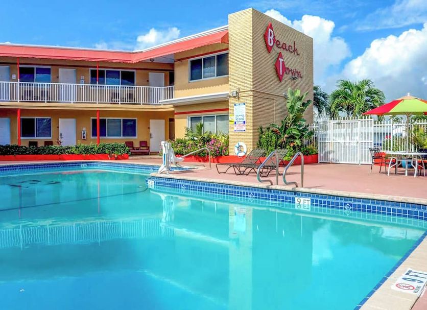 Beach and Town Motel in Hollywood with outdoor pool, sun loungers, and colorful patio seating