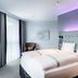 Premier Inn Lübeck City Centre guest room with king bed, gray curtains, and purple ambient lighting in Lübeck