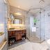 Harbin Lijing Garden Hotel bathroom with glass shower, vanity, and toilet in Harbin