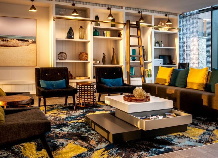 Stayeasy Maputo lounge in Maputo with colorful seating, shelving, and large window light