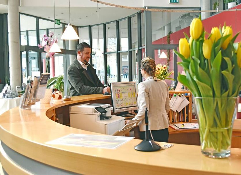 Savoy Hotel Bad Mergentheim reception desk with staff assisting a guest