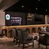 Protea Hotel by Marriott Bloemfontein lounge bar with wicker chairs, backlit counter and fireplace in Bloemfontein