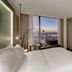 Hilton Munich Airport room with floor-to-ceiling windows and city views at sunset