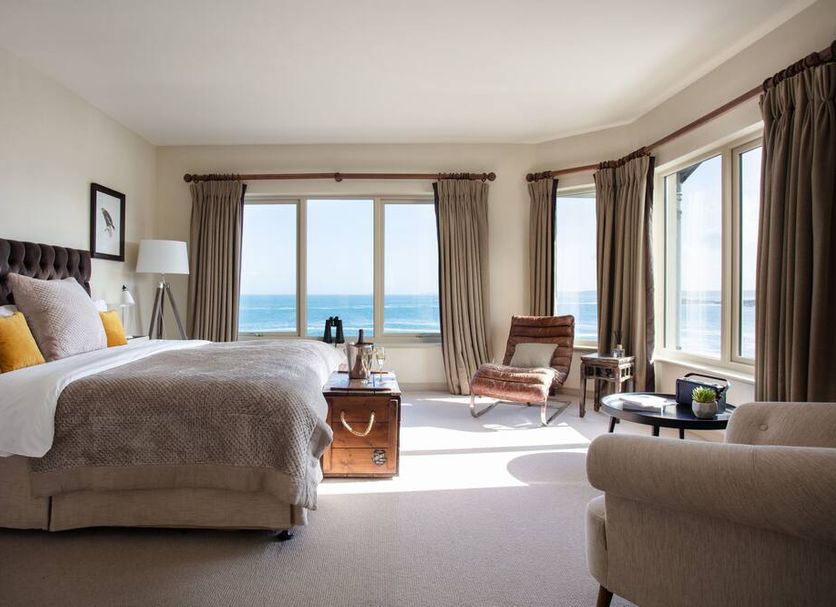 The Lewinnick Lodge, Newquay: sea-view hotel room with large windows, bed, and seating area