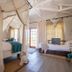 Gondwana Etosha Safari Lodge, Okaukuejo: airy guest room with canopy bed and lounge seating