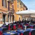 Outdoor dining terrace at Hotel & Restaurant San Marco Ab in Toscolano Maderno with blue table settings and umbrellas