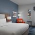 Hampton Inn Russellville guest room with king bed, desk, chair, and window air conditioner