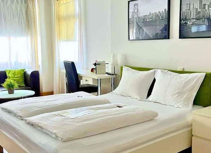 The Square Coburg, Coburg: bright guest room with twin beds, desk, chair and framed city photos