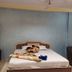 Hotel Sea Coast Digha guest room with double bed, sofa chair, and blue accent wall