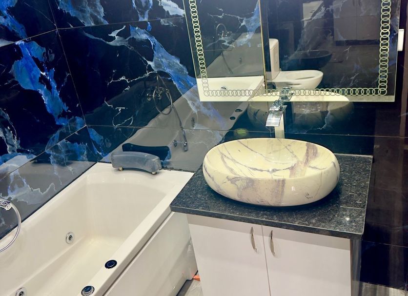 Hôtel Sidi Salem bathroom with marble sink vanity, mirror, bathtub, and blue marble-style wall in Bizerte