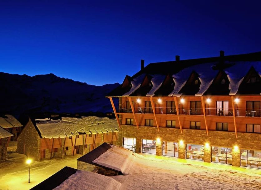 HG Alto Aragón in Formigal at dusk, with snow-covered grounds and warm-lit chalet-style balconies