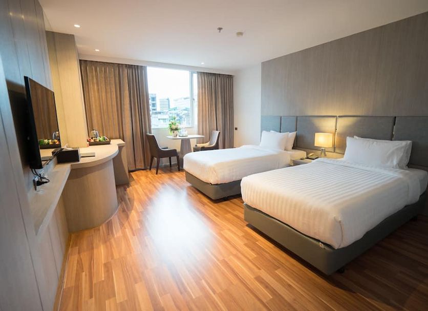 New Season Square Hotel Hat Yai room with two beds, desk, TV and city view