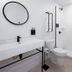 Gravity Haus Revelstoke bathroom with walk-in shower, toilet, black accents and round wall mirror