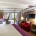 La Freixera in Solsona bedroom with stone walls, hanging chair, red armchair and patio view
