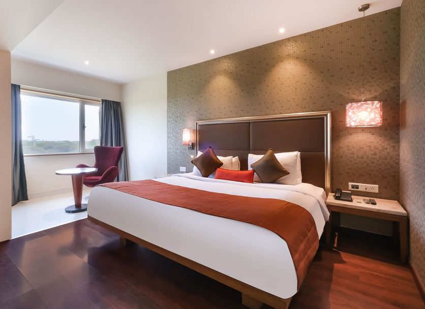 7 Apple Hotel Pimpri Pune room with bed, window seat and city view in Pimpri-Chinchwad