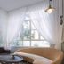 Carmella Boutique Hotel Haifa lounge with curved sofa, armchair, round table, and large draped windows