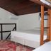 Pousada Innova in Natal room with loft bed, single bed, sloped wooden ceiling and small TV shelf