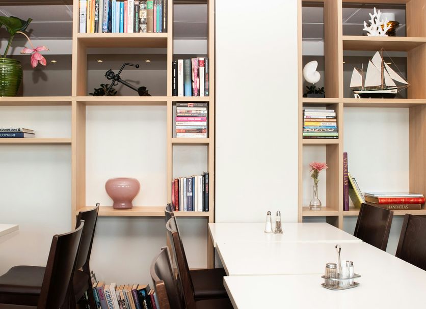 Good Morning+ Göteborg City meeting room with white tables, dark chairs, and built-in shelves in Gothenburg