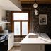 Maison Place Royale by Luxury In Transit in Montreal kitchen with island, pendant lights and exposed brick wall