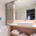 Golden Tulip Aix Les Bains bathroom with tub, glass shower, and vanity in Aix-les-Bains