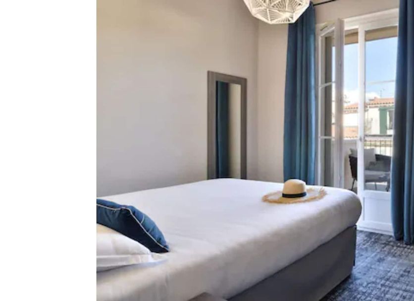 Hôtel Fesch & Spa in Ajaccio room with bed, balcony doors, wall-mounted TV and desk