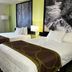 Super 8 by Wyndham Nebraska City guest room with two double beds, forest wall art, and window view